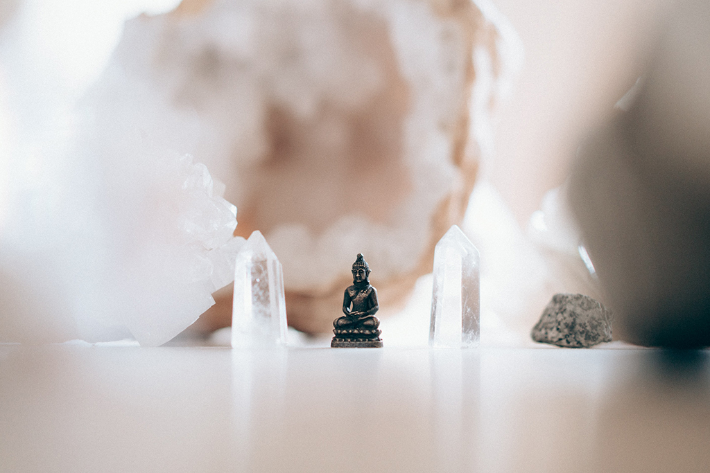 Buddha statue surrounded by crystals.